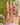 A hand stacked with antique rings on each finger and chains draped across the back